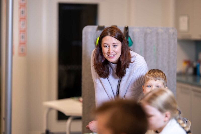 Koulunkäynninohjaaja ja kolme lasta.